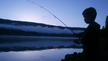 Dusk-silhouette-boy-fishing-canal.